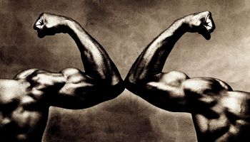 Two male arms, flexing biceps, close-up (toned B&W)