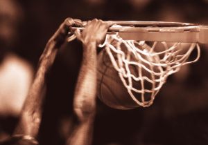 Basketball player dunking ball, close-up (toned B&W)(Composite)