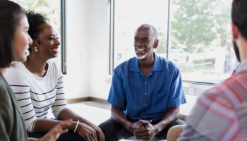 Cheerful man shares during support group meeting