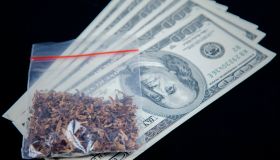 Close-Up Of Marijuana On Paper Currency Over Black Background