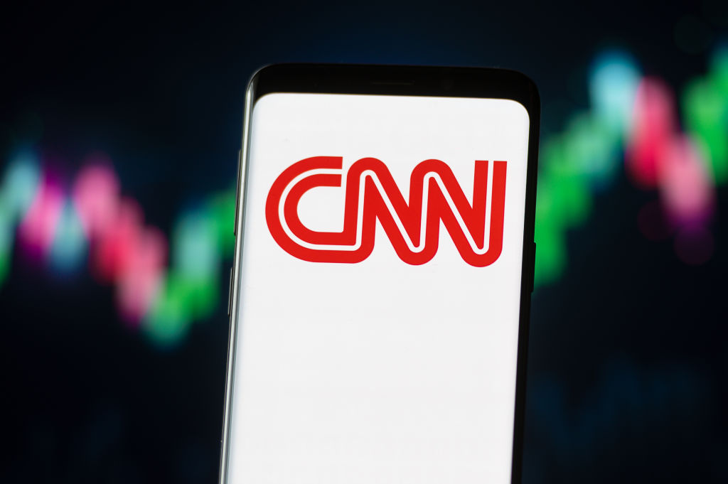 In this photo illustration a CNN logo seen displayed on a...