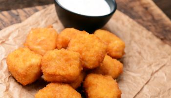 Chicken nuggets with garlic sauce on old wooden background,Romania