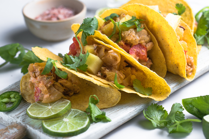The Mexican dish of Tako corn flat cake with vegetable filling on a marble background