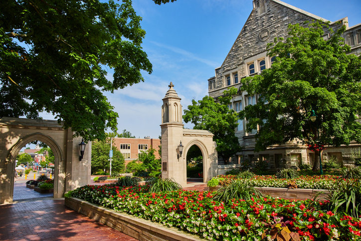 Summer flowers surround Sample Gates at Bloomington Indiana University entrance