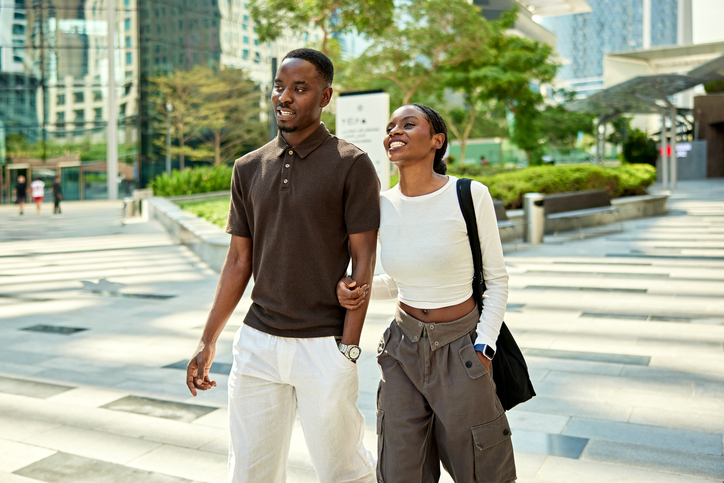Young Dubai office workers arm in arm in business park